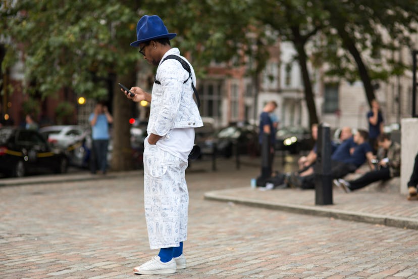 Nabile Quenum wearing a white denim jacket and jeans with blue details, blue socks, a blue hat, and ...