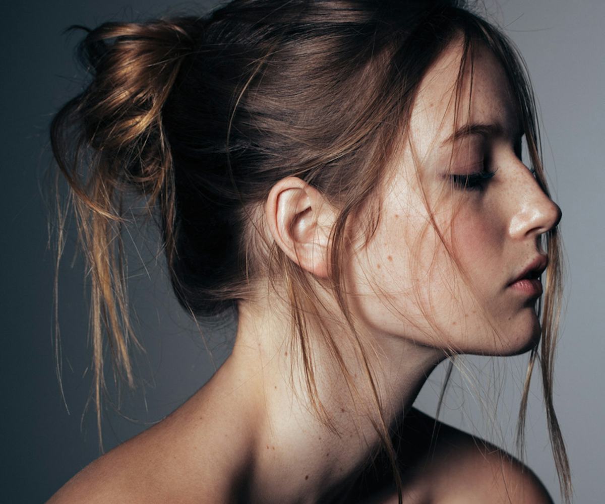 A girl looking down while having a messy bun