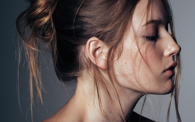 A girl looking down while having a messy bun