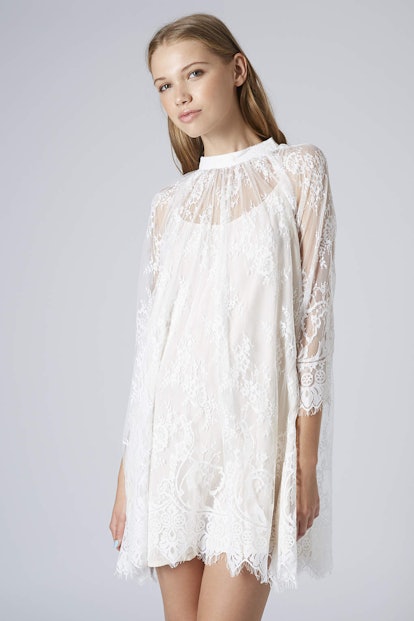A blonde model wearing the White Lace Trapeze Dress from TopShop