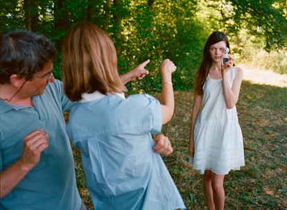 Antonia Wesseloh holding a perfume while a man and a woman are pointing at her