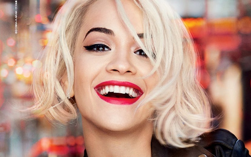 Rita Ora, with her blonde hair and red lipstick, smiling while holding a heart shaped MYNY scent by ...