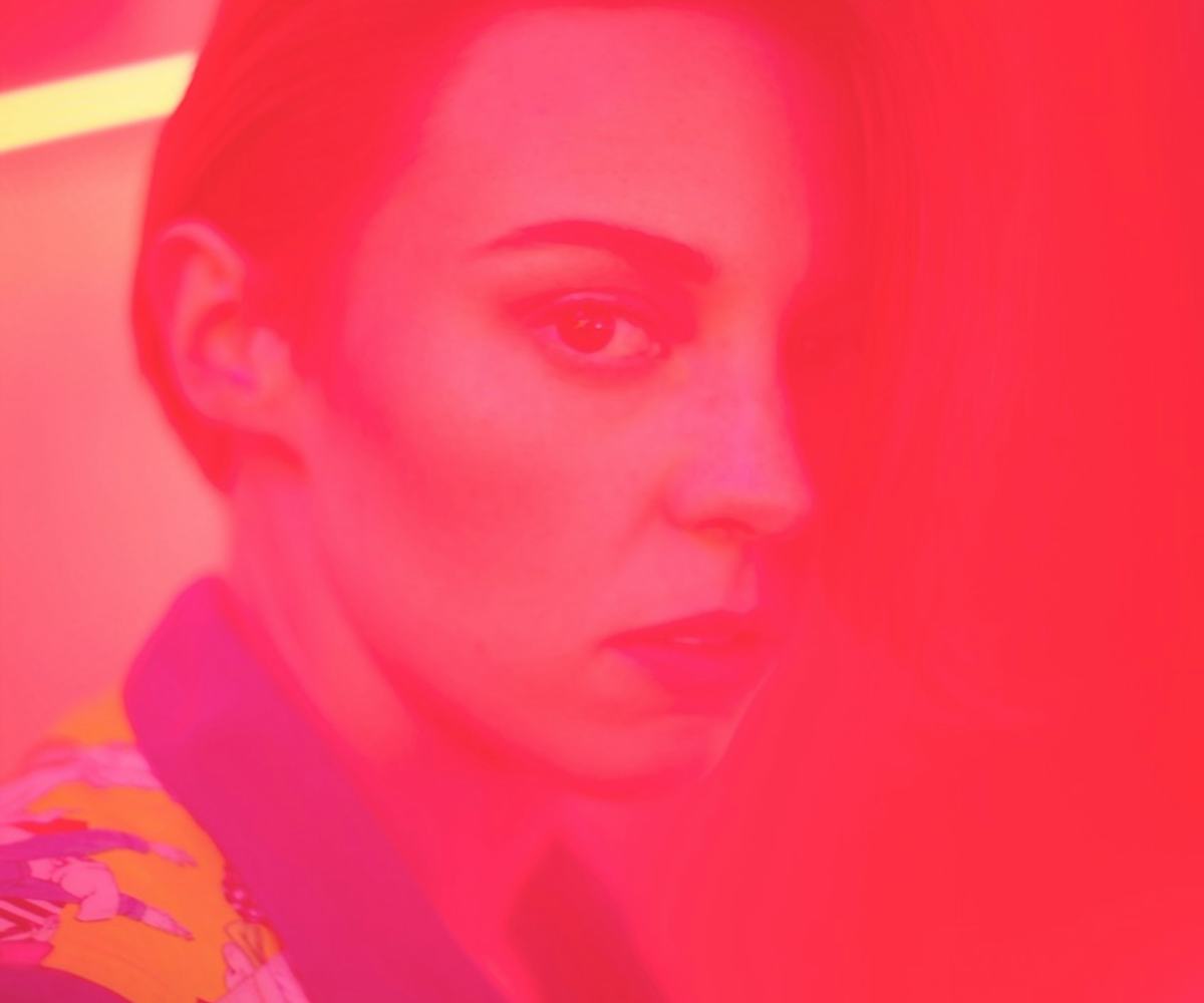 Elly Jackson in a colorful jacket and calm look with red lighting 