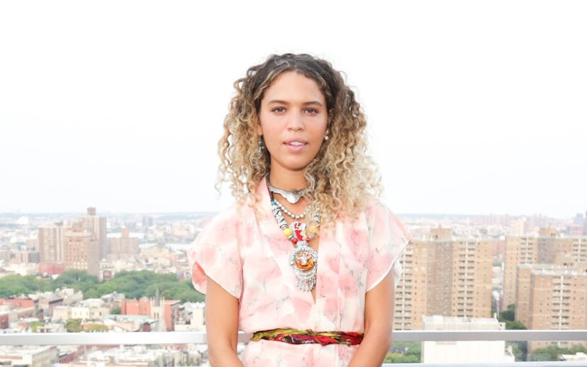 Cleo Wade wearing a breezy outfit including flowy white pants and a floral top 