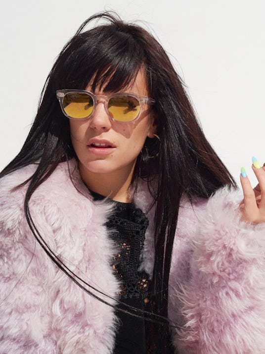 Lily Allen looking to the side  in a pink jacket by Calvin Klein and yellow Cutler & Gross sunglasse...