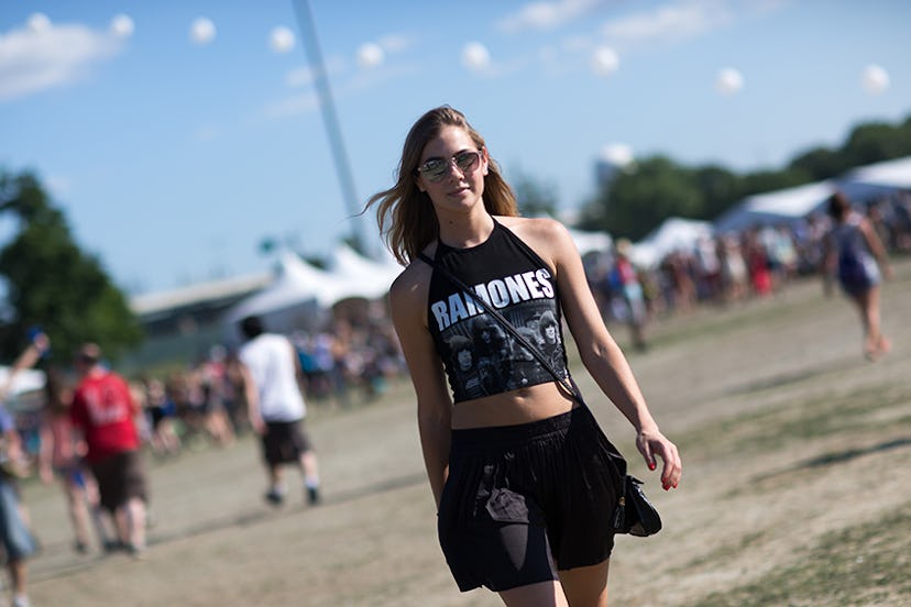 A woman at Governors Ball in a black "Ramones" cropped tank top and a black low-waist skirt 
