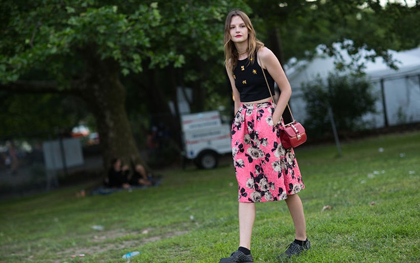 A girl in a black top with yellow details and a flower-patterned pink skirt with pockets at Governor...