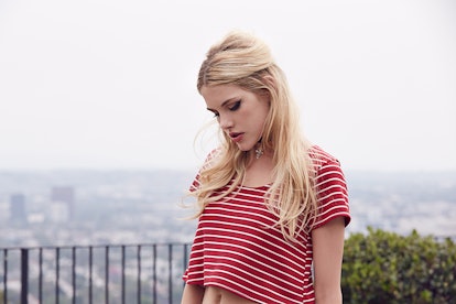 Ashley Smith looking down while wearing a red shirt with white stripes 