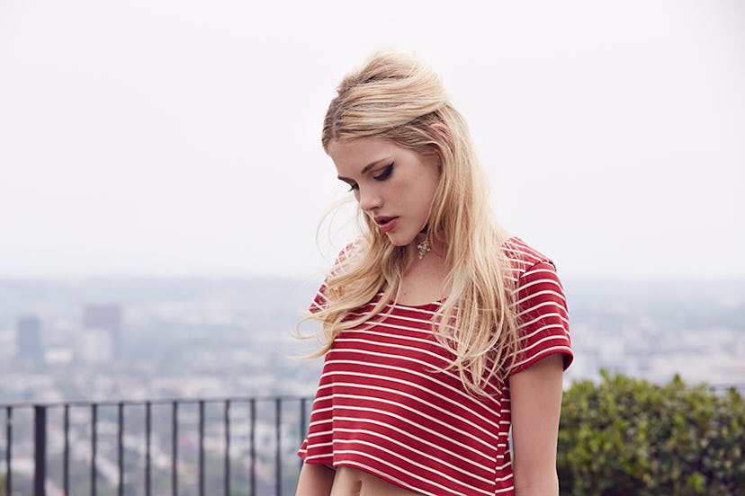 Ashley Smith looking down while wearing a red shirt with white stripes 