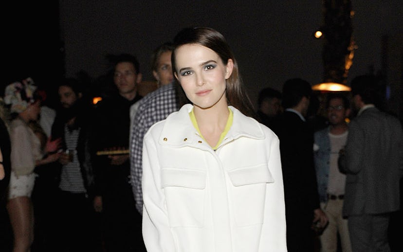 Zoey Deutch in a white button up shirt and a white skirt at a party