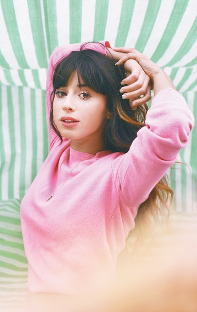 Foxes, an English singer that's part of March track compilation, posing in a pink sweater.