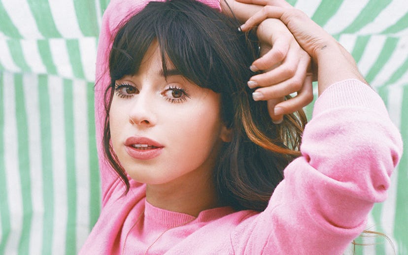 Foxes, an English singer that's part of March track compilation, posing in a pink sweater