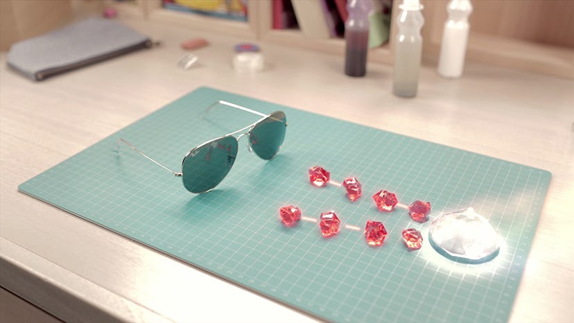 Ray-Ban sunglasses lying on a blue surface next to a diamond and red crystals