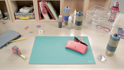 Table with Ray-Ban sunglasses half way in pink Ray-Ban sunglasses case, red Ray-Ban ruler and other ...