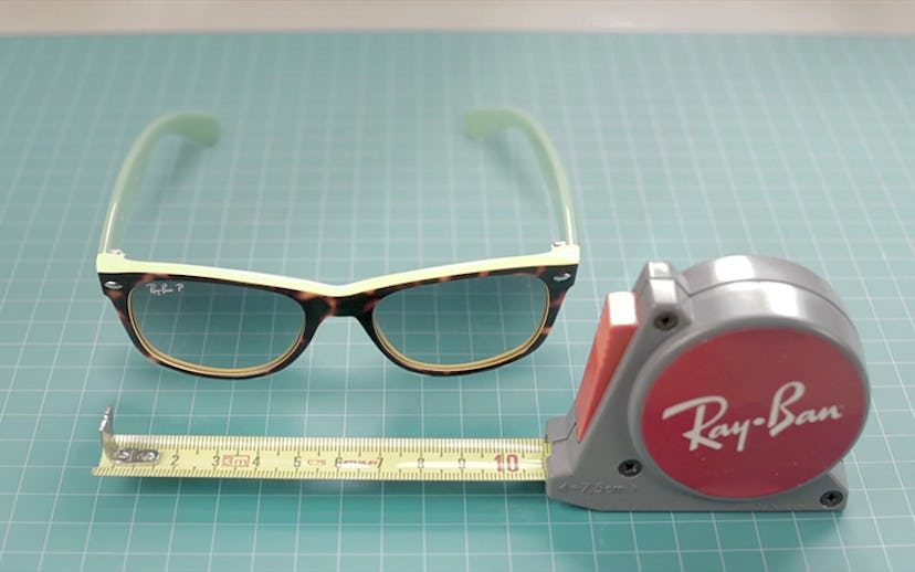Ray-Ban sunglasses lying next to a red Ray-Ban ruler