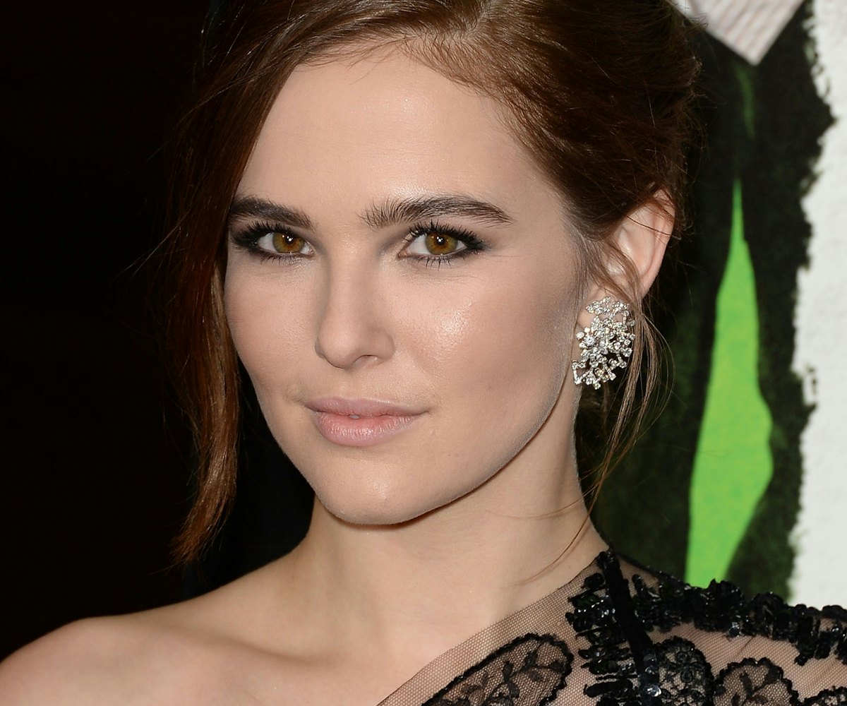 American actress Zoey Deutch in an asymmetric black lace dress and large diamond earrings