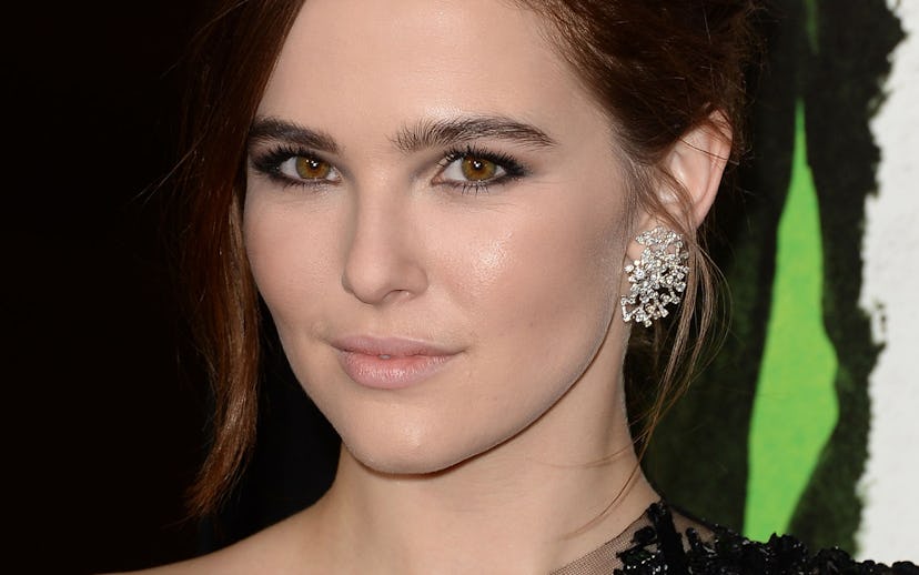 American actress Zoey Deutch in an asymmetric black lace dress and large diamond earrings