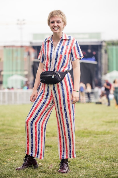 A woman wearing a short-sleeved white jumpsuit with red and blue stripes, with polka dots inside the...