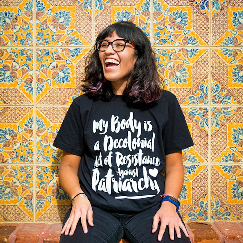 A woman laughing in a black t-shirt by the Nalgona Positive Shop 