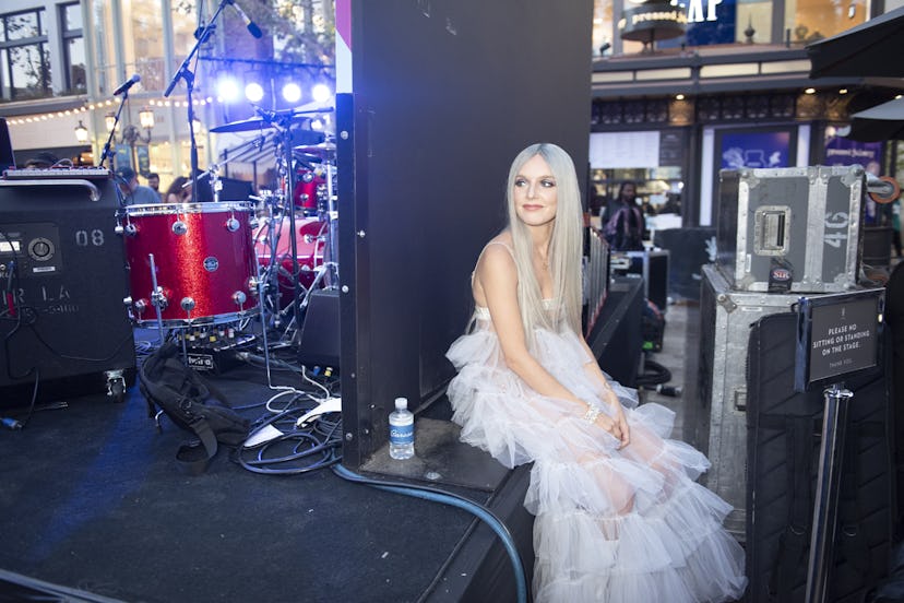 Zolita sitting behind stage