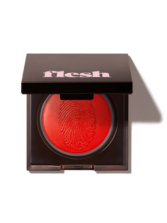 Flesh Beauty's Swipe Flesh Lip Color in red, in black packaging with white writing on it 