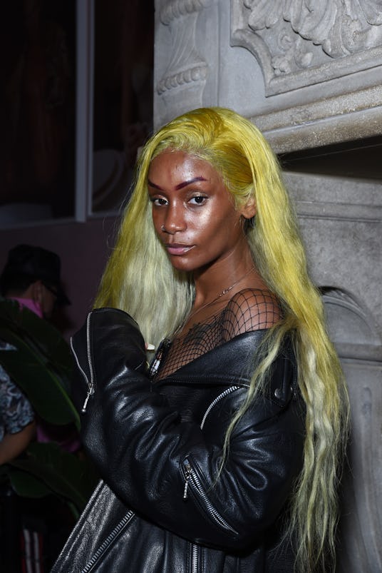 Woman with yellow hair and a black leather outfit, enjoying her time at Lauren Jauregui's Nylon part...