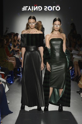 Two models at the Flying Solo show in black leather Jo Kilda dresses, one off-the-shoulder and the o...