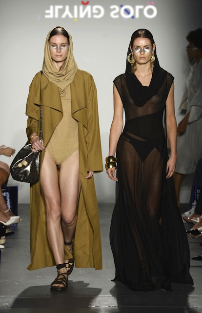 Two models in the Flying Solo show in Lacher Prise Apparel: a bodysuit and trench coat and a sheer b...