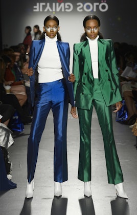 Two models in the Flying Solo show in suits by Bleis Madrid, one is in green and the other in blue