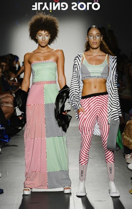 Two models in the Flying Solo show in Ricardo Seco: a green and red top and skirt set and a workout ...