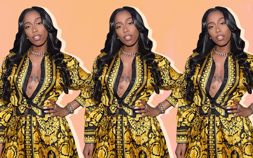 Kash Doll wearing a yellow and black dress with a ribbon, with a star tattoo on her chest