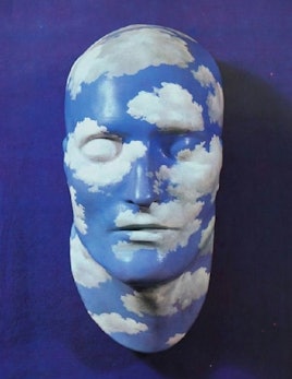 Head doll with clouds and sky drawn on it