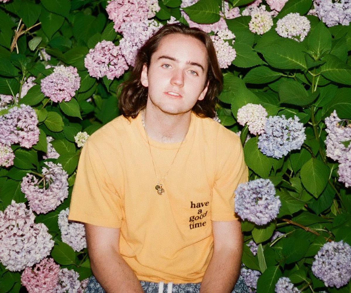 Kid Hastings in a yellow shirt on a floral background