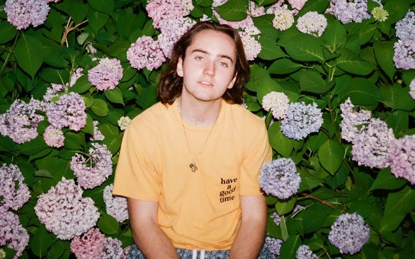 Kid Hastings in a yellow shirt on a floral background