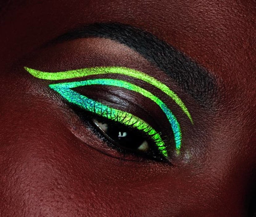 Girl's eye with a green and yellow eyeliner 
