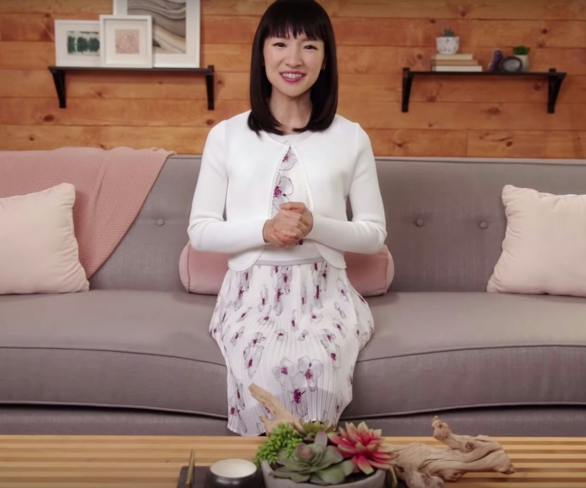 Marie Kondo sitting on a couch in a scene from her "Tidying Up".