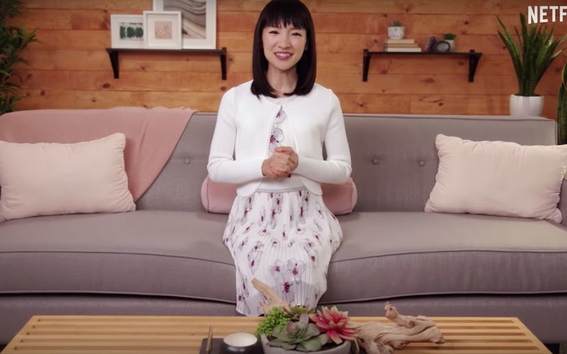 Marie Kondo sitting on a couch in a scene from her "Tidying Up"