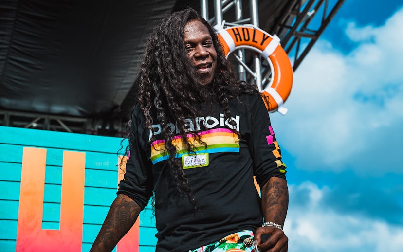 Big Freedia while performing in a black long-sleeved shirt with a polaroid center part print a flora...