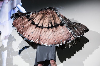 A couture fashion piece, created by a computer, looking like bird feathers that are reflecting light...
