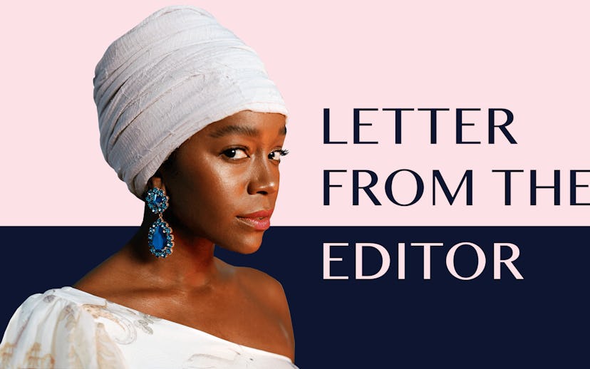 Aja Naomi King in a white turban and white one-shoulder top