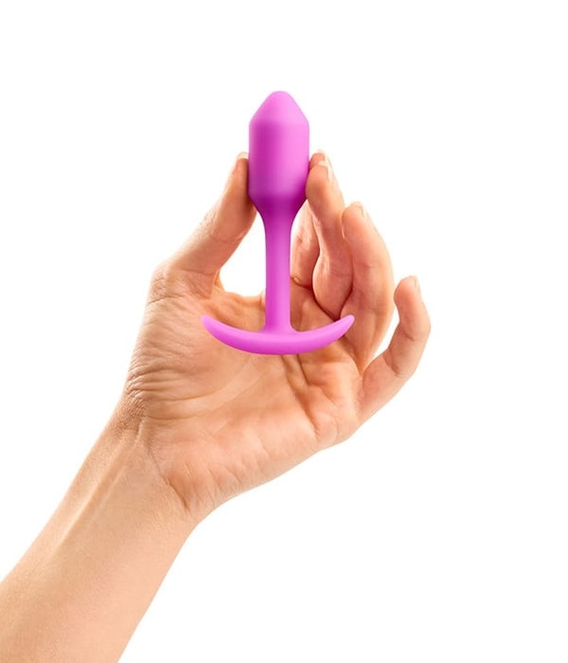 A hand holding the B-Vibe Snug Plug in purple 