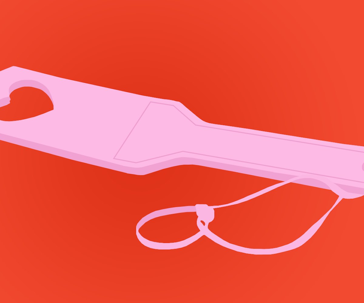 Pink spanking sex toy on a red background