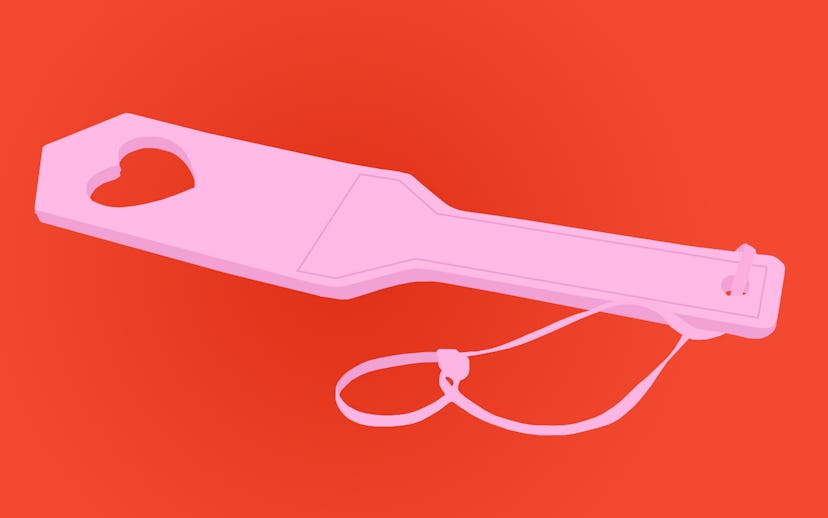 Pink spanking sex toy on a red background