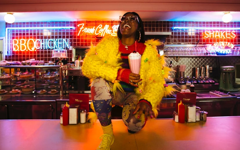 Girl in a coffee shop holding a milkshake and smiling