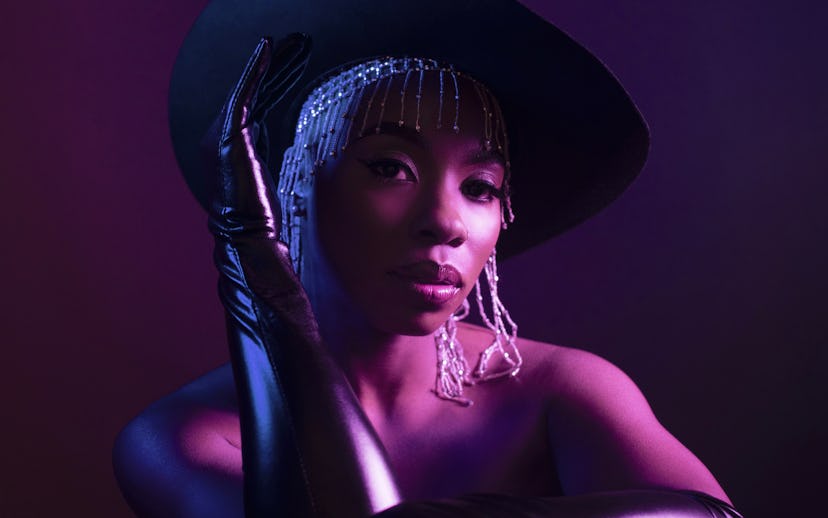 Jessy Wilson in a fringe metal headpiece under a black fedora and long leather gloves in her new 'Oh...