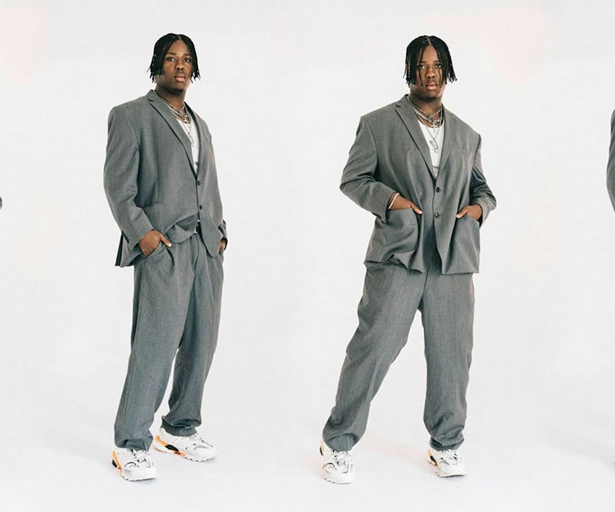 Denzel Dion posing in a classic gray oversized suit  