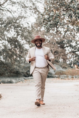 Menswear influencer Kelvin Davis wearing a suit and a brown hat