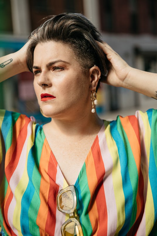 Photographer Lydia Hudgens wearing a colorful piece with her hands in her hair