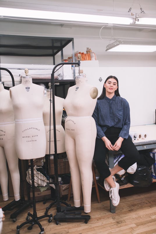 Founder of Henning, Lauren Chan wearing a blue hoodie sitting next to plastic models