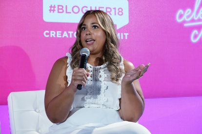Co-founder of CurvyCon, Chastity Garner Valentine wearing a white dress and talking in a microphone